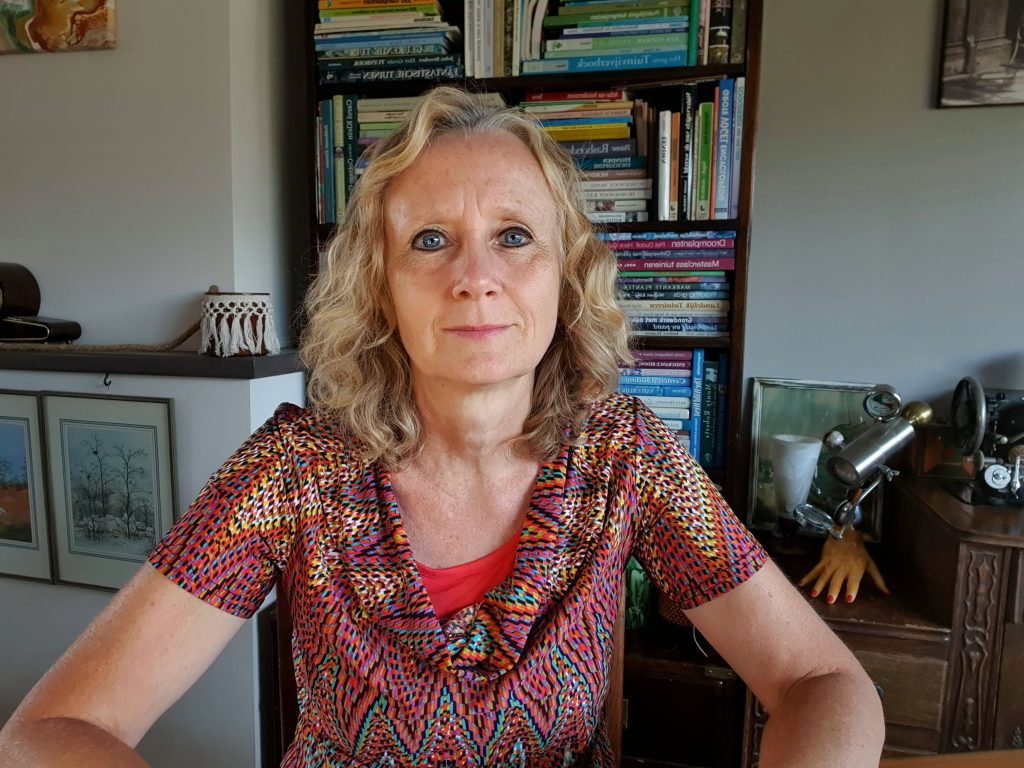 Gwen-Konings-Zittend-aan-Tafel-voor-Boekenkast